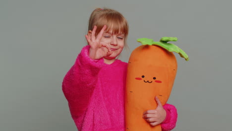 Young-toddler-school-girl-in-sweater-looking-approvingly-at-camera-showing-okey-gesture,-like-sign