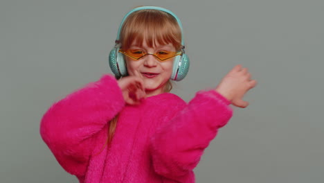 Happy-preteen-child-girl-kid-listening-music-via-headphones-and-dancing-disco-fooling-around
