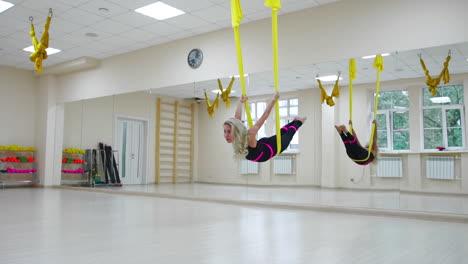 The-concept-of-sports-for-a-healthy-lifestyle.-The-girl-has-been-aerology-of-antigravity-relaxes-and-swings-on-the-canvas-in-a-white-room