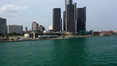 Drone-shot-over-the-Detroit-river,-toward-the-General-Motors-buildings-in-Michigan,-USA