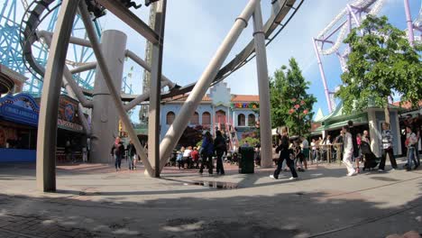 Roller-coaster-with-people-suspended-below-cart-is-passing-at-high-speed-above-ground---Grona-Lund-Tivoli-Stockholm-Sweden