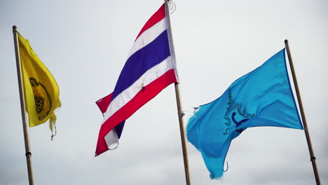 Ondeando-La-Bandera-De-Tailandia-Y-La-Isla-Koh-Phi-Phi-Durante-El-Día-Ventoso-Y-El-Cielo-Nublado