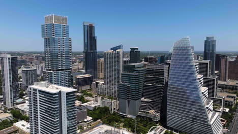 Aerial-view-rising-around-modern-skyscrapers-in-downtown-Austin,-sunny-Texas,-USA