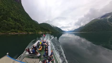 Sightseeing-tourist-boat-crusing-Fjaerlandsfjorden-in-Sogn-Norway---Wide-angle-looking-at-stern-of-boat-underway-in-majestic-fjord-landscape