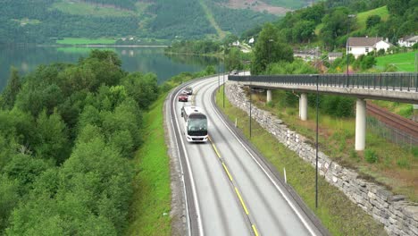 Bus-and-cars-driving-road-E16-to-Voss---Slow-tilt-down-from-front-view-to-top-down-view-when-passing-below-camera