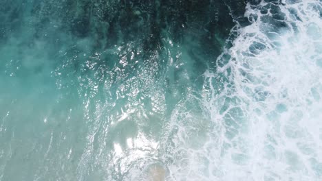 Drone-top-down-perspective-of-waves-crashing-on-Diamond-Beach-in-Nusa-Penida-Island-Bali,-Indonesia