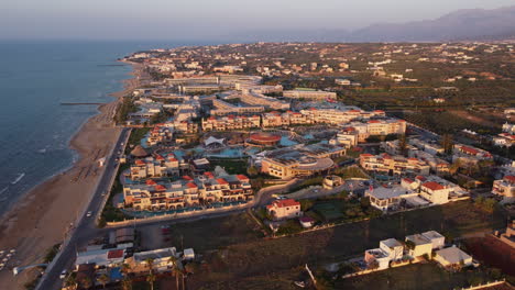 Resorts-and-Hotels-at-Crete's-Coast,-Chersonissos---Aerial-Orbit