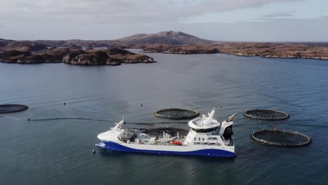 Kreisende-Drohnenaufnahme-Eines-Fischzuchtbrunnenbootes-In-Der-Nähe-Der-Insel-Uist
