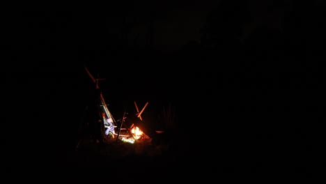 People-in-the-distance-gathered-around-a-camp-fire-ou-in-the-Australian-bush