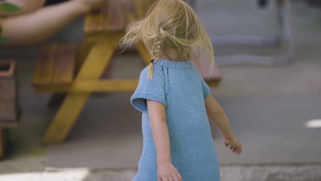 Ein-Kleines-Blondes-Mädchen-In-Einem-Blauen-Kleid-Tanzt-Und-Dreht-Sich-Fröhlich