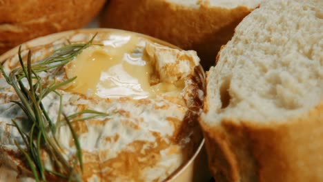 Hand-Dipping-Baguette-Bread-in-Freshly-Baked-French-Camembert-Cheese-with-Rosemary