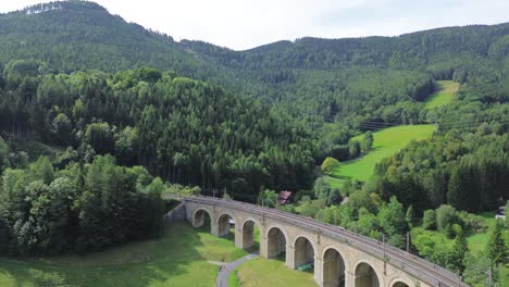 Semmering-Railway-World-Heritage-Unesco-Site-in-Austria-filmed-from-above-with-a-drone-in-4K-surrounded-by-forest