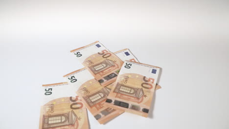 Fallende-Euro-Banknoten-Auf-Einem-Weißen-Hintergrundtisch