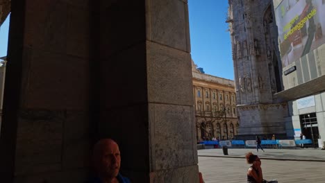 Shot-of-large-digital-screen-surrounded-by-historic-buildings-in-the-city-center-in-Milan,-Italy-on-a-sunny-day