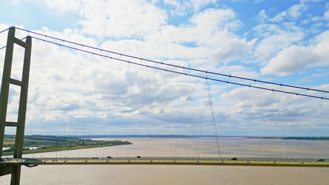 Aerial-drone's-view-unveils-Humber-Bridge,-the-12th-largest-single-span-on-Earth,-spanning-River-Humber,-facilitating-traffic-flow-between-Lincolnshire-and-Humberside