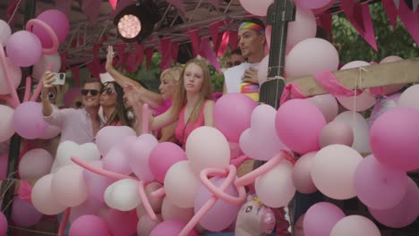 Truck-passing-by-with-a-lot-of-pink-balloons-and-women-in-pink-dresses-during-the-Antwerp-Pride-Parade-2023-in-Belgium