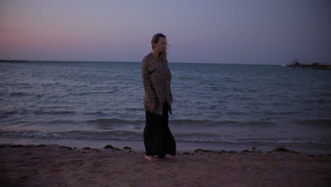 Eine-Schöne-Junge-Frau-Am-Windigen-Strand-Bei-Sonnenuntergang