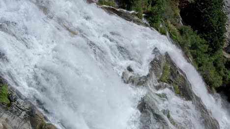 Close-up-aerial-view-of-powerful-waterfall-cascading-down-steep-cliff-face