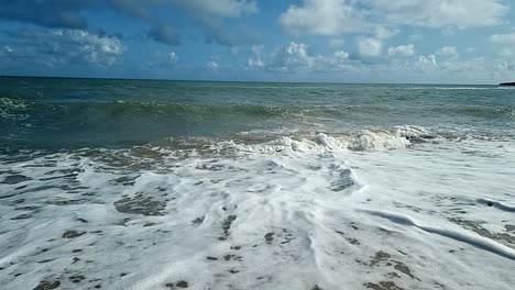 Slow-motion-ocean-waves-splashing-onto-scenic-sandy-island-beach-soothing-tranquil-shoreline
