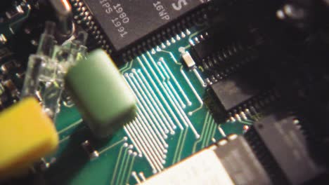 Macro-closeup-of-circuit-board-intricacies-and-soldered-cable-wires-to-chips