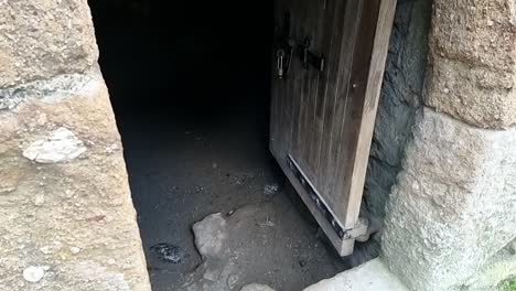 Paranormal-ghostly-orb-light-floating-across-old-medieval-wooden-doorway-entrance