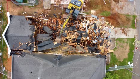 A-top-down-drone-shot-of-an-excavator-tearing-down-a-building