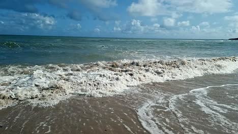 Slow-motion-ocean-waves-splashing-onto-scenic-sandy-island-beach-blue-sky-romantic-tropical-shoreline