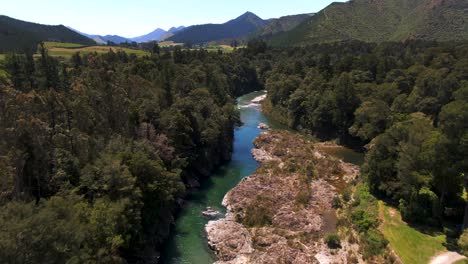 A-Turqoise-Blue-River-Flowing-Through-The-Lush-Green-Forest-Valleys-Of-New-Zealand