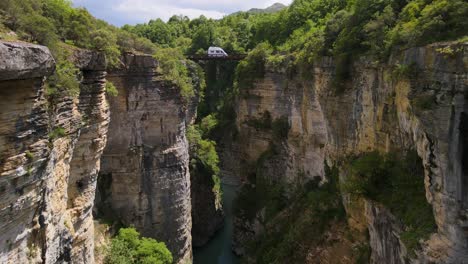 Luftaufnahme:-Ruhiger-Fluss,-Felsige-Klippen,-üppiges-Grün,-Osum-Flussbrücke-In-Albanien