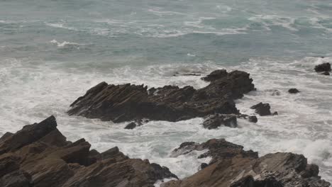 Slow-motion-shot-of-waves-crashing-against-rocks-off-the-Newquay-coast