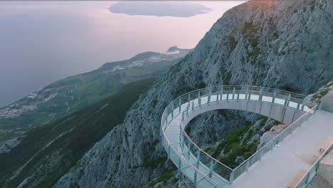 Sunset-view-of-the-famous-skywalk-at-the-top-of-the-Biokovo-Nature-Park-in-Southern-Croatia-built-for-sustainable-tourism,-Drone-shot