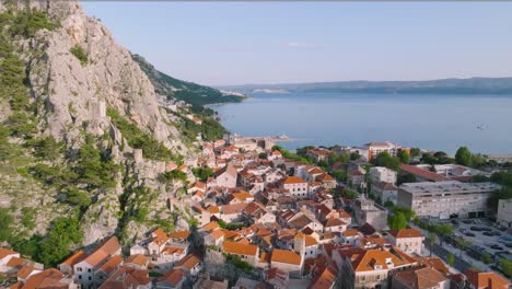 European-medieval-old-town-of-Omis,-Croatia,-aerial-dolly-out,-summer-sunrise