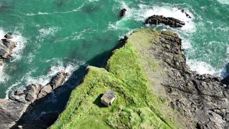 Drone-Coast-of-Ireland-Looking-down-static-shot-of-old-WW2-observation-post-on-sea-cliffs-at-The-Copper-Coast-Waterford-on-a-summer-day