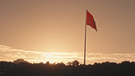 Riesige-Türkische-Flagge-Weht-Vor-Dem-Leuchtend-Orangefarbenen-Sonnenuntergangshimmel,-Istanbul,-Slomo