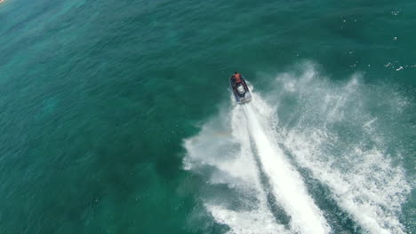Man-Riding-Jet-Ski-In-The-Blue-Sea-During-Summer-Vacation