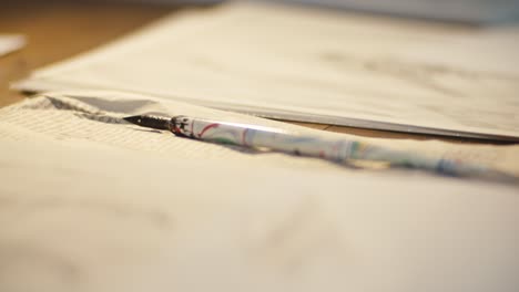 male-hand-picking-up-an-ink-pen,-closeup