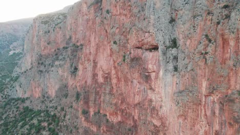 Drone-parallax-pullback-around-sheer-huge-wall-of-rock-climbing-paradise,-leonidio-greece