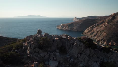 Drohne-Erhebt-Sich-über-Cairn-Auf-Dem-Gipfel-Und-Zeigt-Die-Atemberaubende-Weite-Des-Ozeans-Von-Der-Griechischen-Insel-Syros-Aus