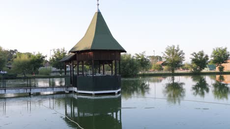 Gazebo-on-dock-in-middle-of-small-pond-at-event-venue,-ready-for-wedding