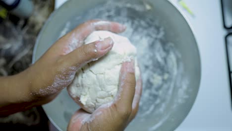 Nahaufnahme-Der-Hände-Einer-Afroamerikanischen-Frau,-Die-In-Zeitlupe-Pizzateig-In-Einer-Silbernen-Pfanne-Kneten