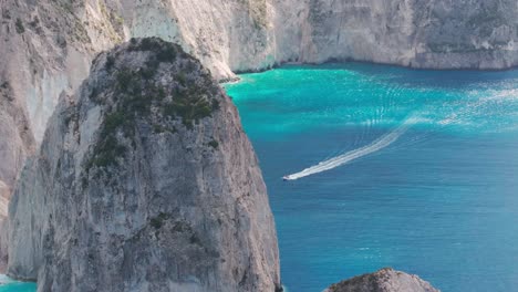 Drone-Shot-of-Speedboat-Sailing-in-Ionian-Sea-Under-Cliffs-of-Zakynthos-Island,-Greece-50fps