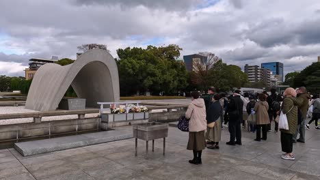 Hiroshima-peace-memorial,-visitors-bowing-an-praying