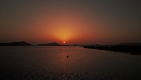 Segelboot-Schwimmt-Ruhig-Im-Ozean-Verankert,-Drohne-Zur-Untergehenden-Sonne-In-Der-Abenddämmerung-über-Pylos-Griechenland