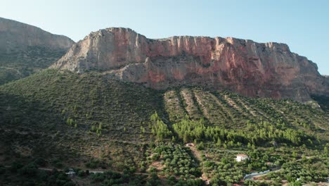 Panoramic-establish-shot-of-rocky-cliff-mountain-in-leonidio-greece,-awaiting-climbers-to-challenge-routes