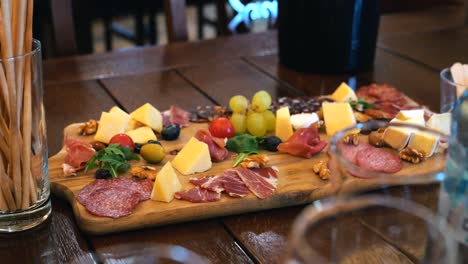 Cheese-plate-with-meat,-nuts,-fruits,-and-vegetables-at-a-wine-tasting-event