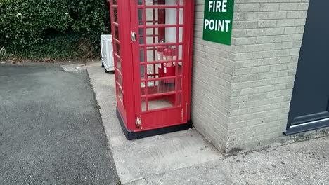 Veraltete-Britische-Rote-Telefonzelle-In-Zeitlupe,-Die-Für-Die-Aufnahme-Eines-Feuerlöschers-Umgebaut-Wurde