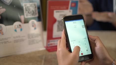 QR-code-payment,-customer-using-smartphone-for-paying-at-shop