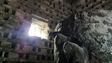 Inside-old-Penmon-priory-dovecot-with-stone-wall-nesting-box-and-window-light