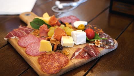 Cheese-plate-with-meat,-nuts,-fruits,-and-vegetables-at-a-wine-tasting-event