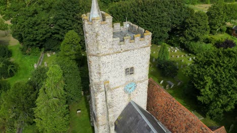 A-close-up-arc-shot-of-the-church-tower-of-Holy-Cross-church-in-Goodnestone